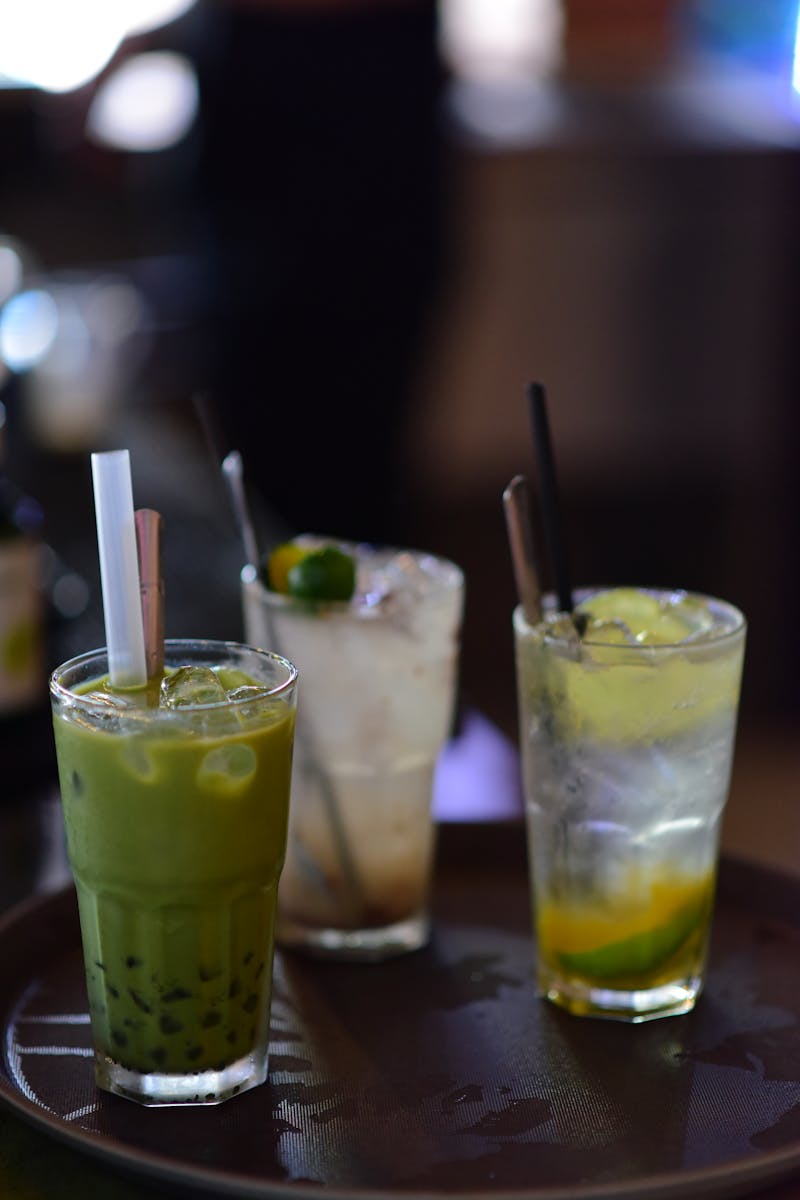Three refreshing non-alcoholic drinks on a tray, perfect for summer refreshment.